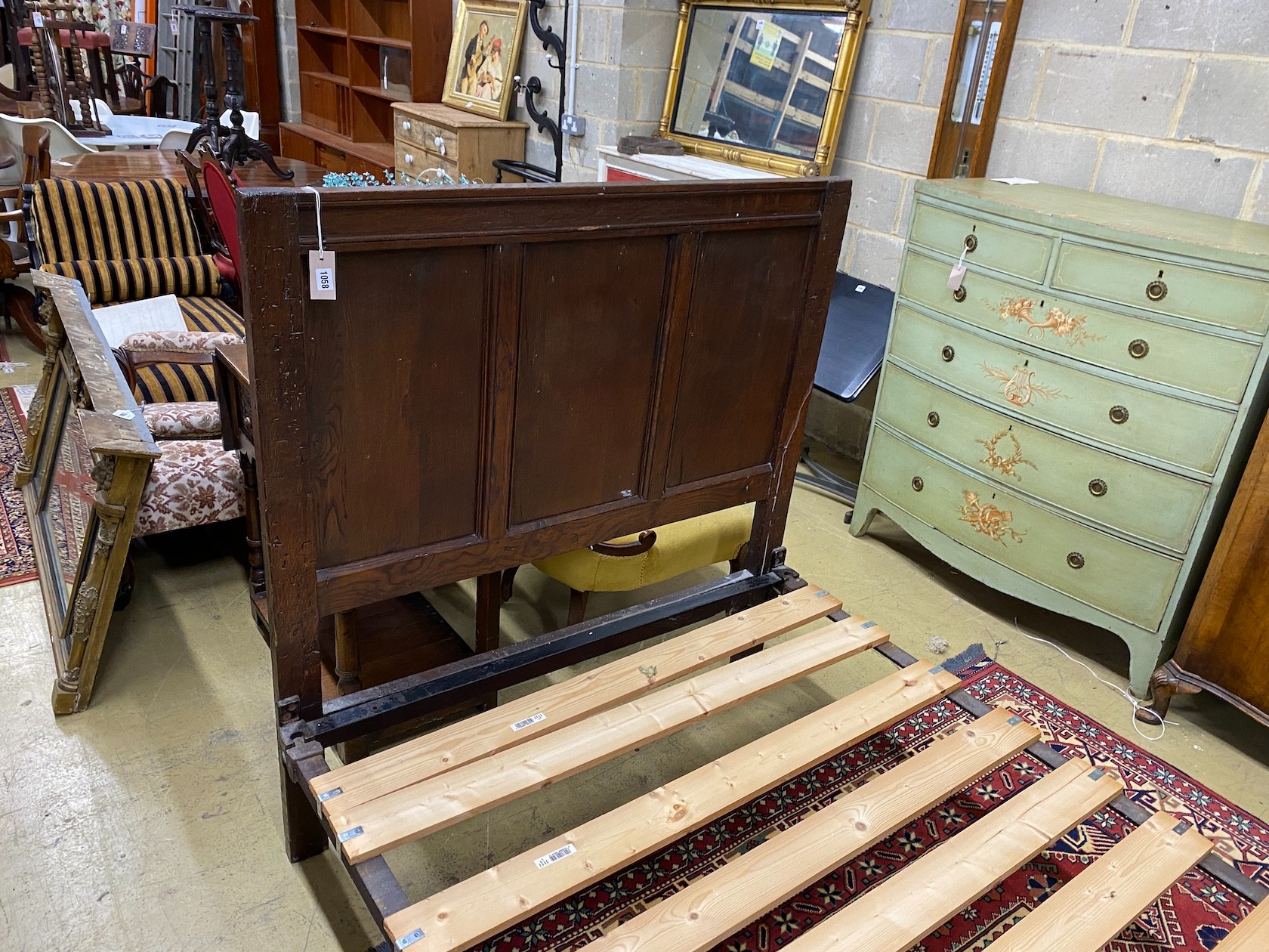 An 18th century style panelled oak bedframe, length 198cm, width 122cm, height 130cm